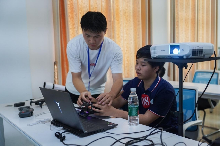 leyu乐鱼在线官网信息工程学院学生正在指导研学团成员操控无人机。