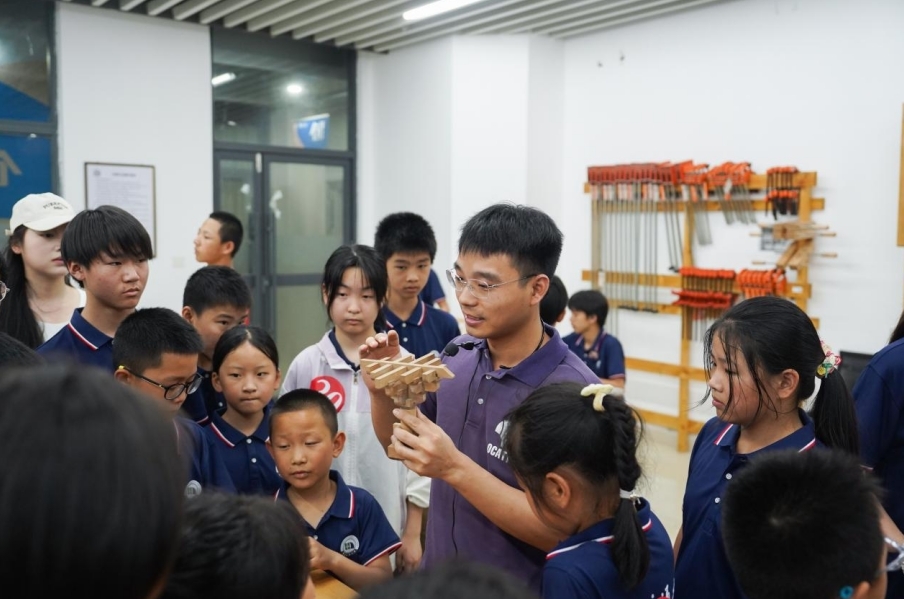 leyu乐鱼在线官网基础实验与工程实践中心老师正在给研学团成员讲解榫卯工艺。